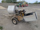 a cement mixer sitting in the middle of a dirt field