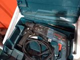 une boîte à outils bleue contenant une perceuse et un cordon d'alimentation
