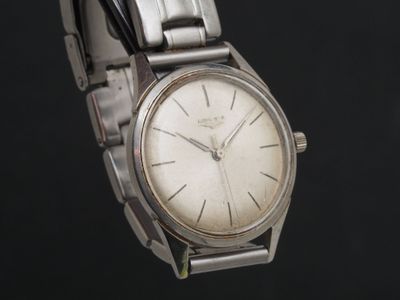 une montre-bracelet en argent avec un cadran blanc sur fond noir