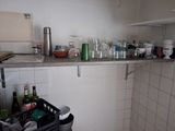 a small kitchen with a lot of clutter on the counter