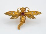 une photo d'une broche en forme de libellule en or, sertie de diamants