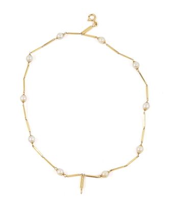 un bracelet en chaîne d'or orné de perles et d'une breloque en forme de croix