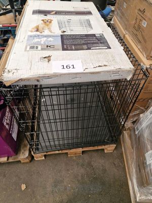 a dog in a cage sitting on top of a pile of boxes