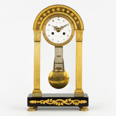 une horloge posée sur un support sur une surface blanche