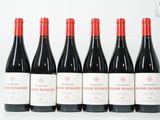 six bouteilles de vin rouge sont alignées sur une surface blanche
