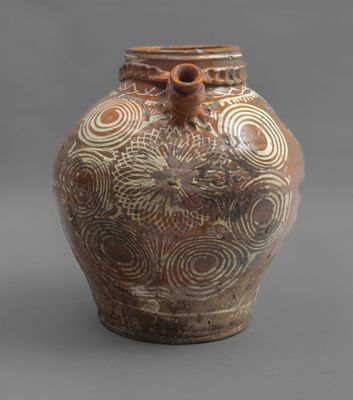 an image of a brown and white vase on a gray surface