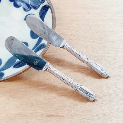 a plate with two knives on it and a plate with two knives on it