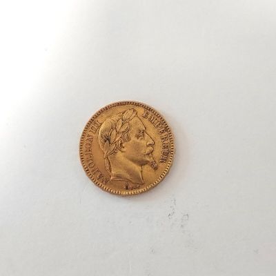 gros plan d'une pièce d'or sur une surface blanche