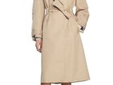 a woman in a beige trench coat and black shoes