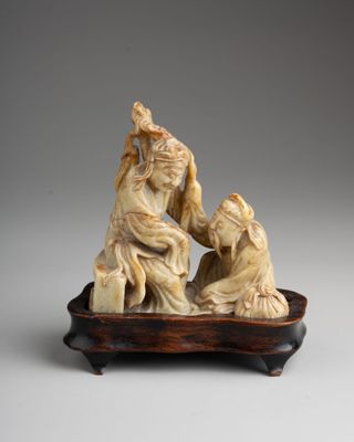 Figurine chinoise en ivoire sculpté représentant un homme et une femme, posée sur un plateau