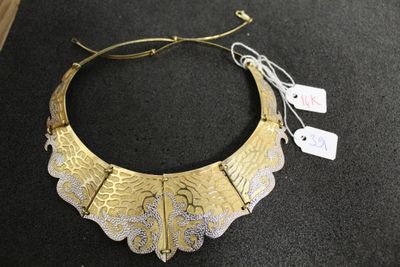 gros plan d'un collier en or sur une surface noire
