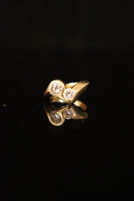 a close up of a gold ring with diamonds on a black surface