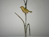 sculpture représentant un oiseau perché sur une branche d'une plante