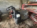 une machine posée par terre à côté d'un tas de bois