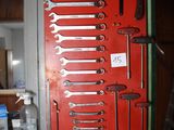 a red wall with a bunch of tools hanging on it