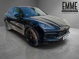 Une Porsche Cayenne noire est garée dans un showroom.