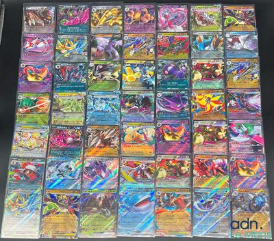 une table sur laquelle sont empilées de nombreuses cartes Pokémon différentes les unes sur les autres