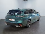 the rear end of a green car parked in a showroom