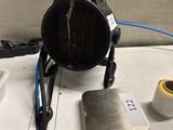 une photo d'un radiateur d'appoint posé sur une table, à côté d'un mètre ruban et d'une bobine de fil