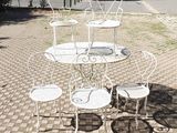 a white table and four chairs on a brick sidewalk