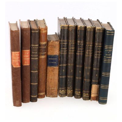 de nombreux livres anciens alignés les uns à côté des autres sur une surface blanche