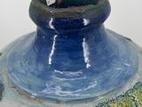 a large blue vase with a painting on it