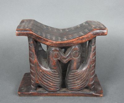 une vieille sculpture en bois représentant deux oiseaux posés sur une table