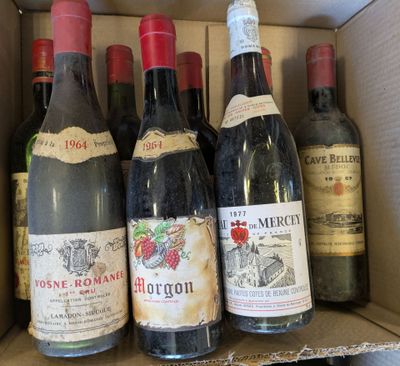 Plusieurs bouteilles de vin sont posées dans une boîte en carton sur une étagère