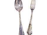 two silver spoons and a fork on a white background