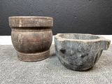 une paire de mortiers anciens en bois et un bol en pierre posés sur une table