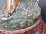 a bronze statue of a woman ' s foot on a rock