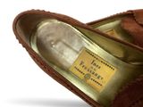 pair of women ' s brown sued slippers with a label on the heel