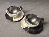two cups and saucers sitting on a table