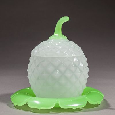 une pomme de pin en verre ornée d'une feuille verte