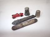 a silver thimble, a silver thimble, a silver thimble, and a silver thimble on a white surface