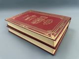 un vieux livre rouge posé sur une table blanche