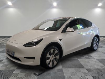 the white tesla model x is parked in a room with a checkered floor