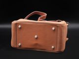 an image of a brown leather bag on a black background