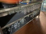 a metal shelf with glasses and plates on it
