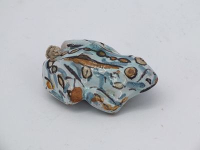 a small blue and brown bead on a white surface