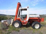 un tracteur rouge garé dans l'herbe