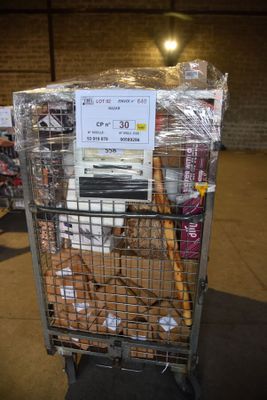 un chariot rempli de beignets dans un magasin où est accrochée une enseigne