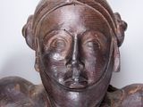 a wooden statue of a man with a helmet on his head