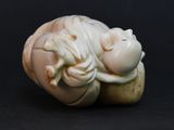 a small figurine of a baby laying on top of a banana