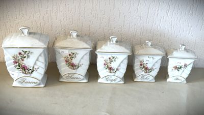 quatre boîtes blanches ornées de fleurs, posées sur un comptoir