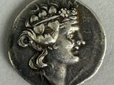 an old coin with a woman ' s head and a crown on it