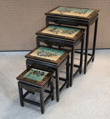 trois tables gigognes noires et dorées ornées de motifs peints
