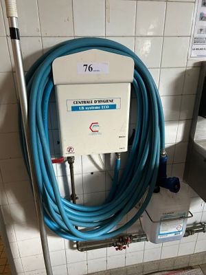 a blue hose attached to a wall in a public bathroom