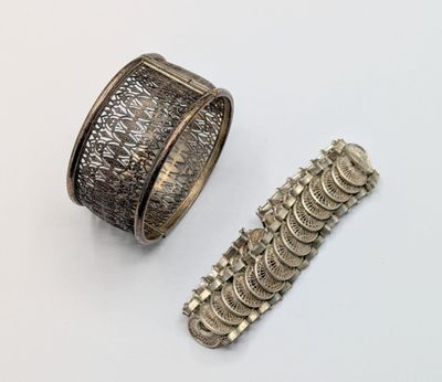a close up of a bracelet and a ring on a white surface