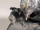 a statue of a bird sitting on top of a rock